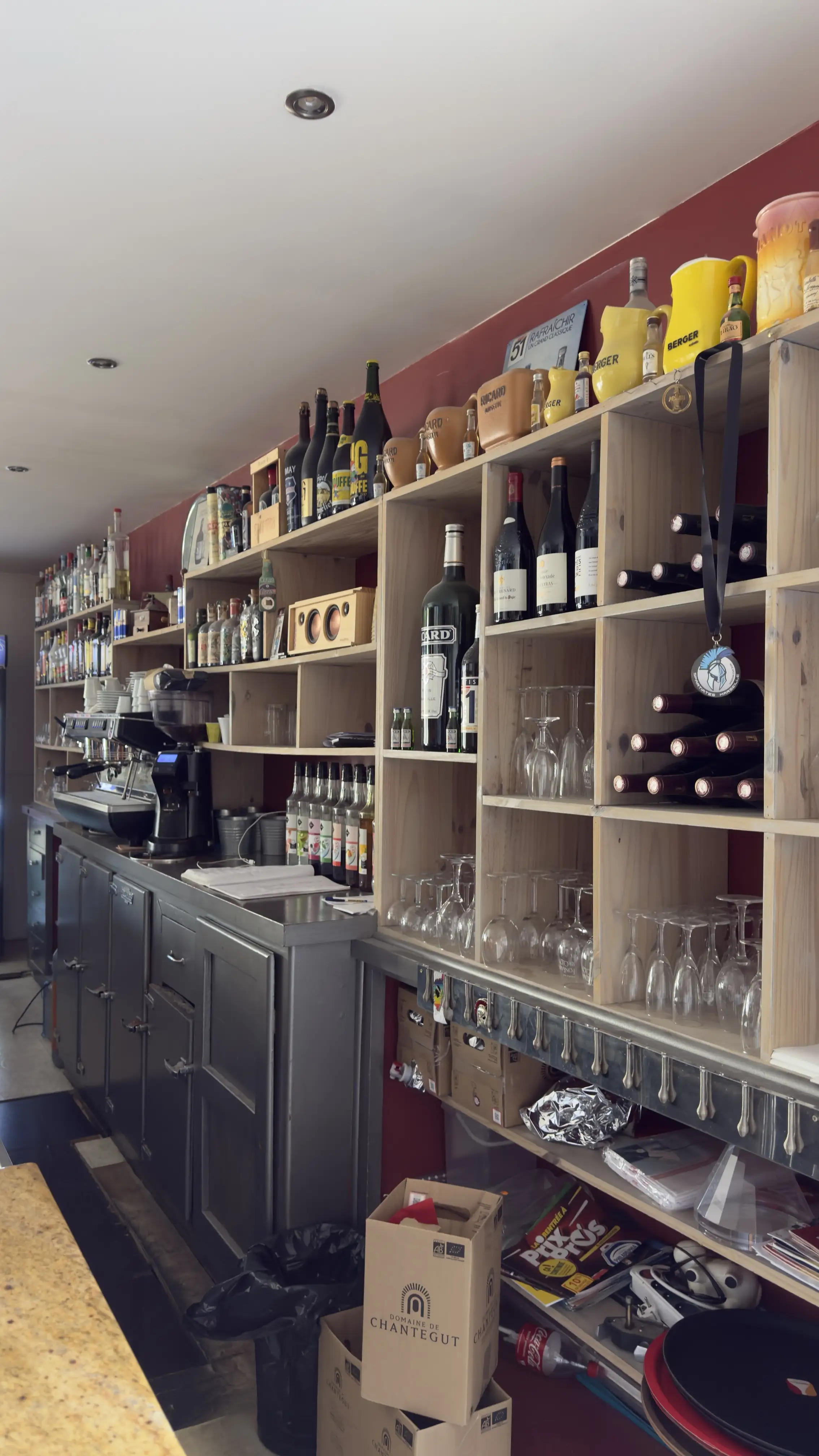 Les étagères de bouteilles et de verres derrière le bar