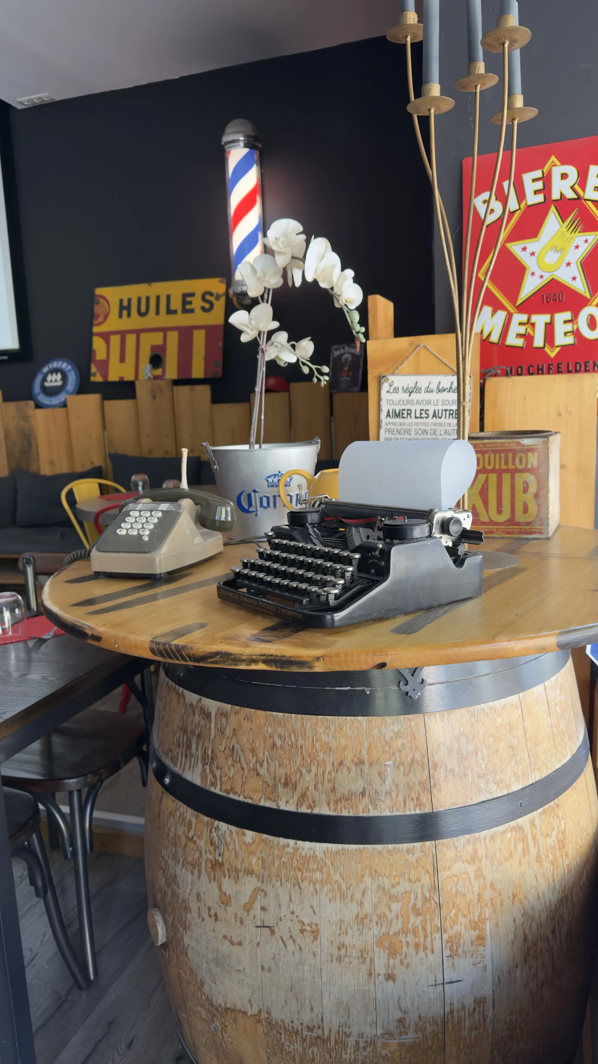 Machine à écrire et téléphone anciens posés sur un tonneau